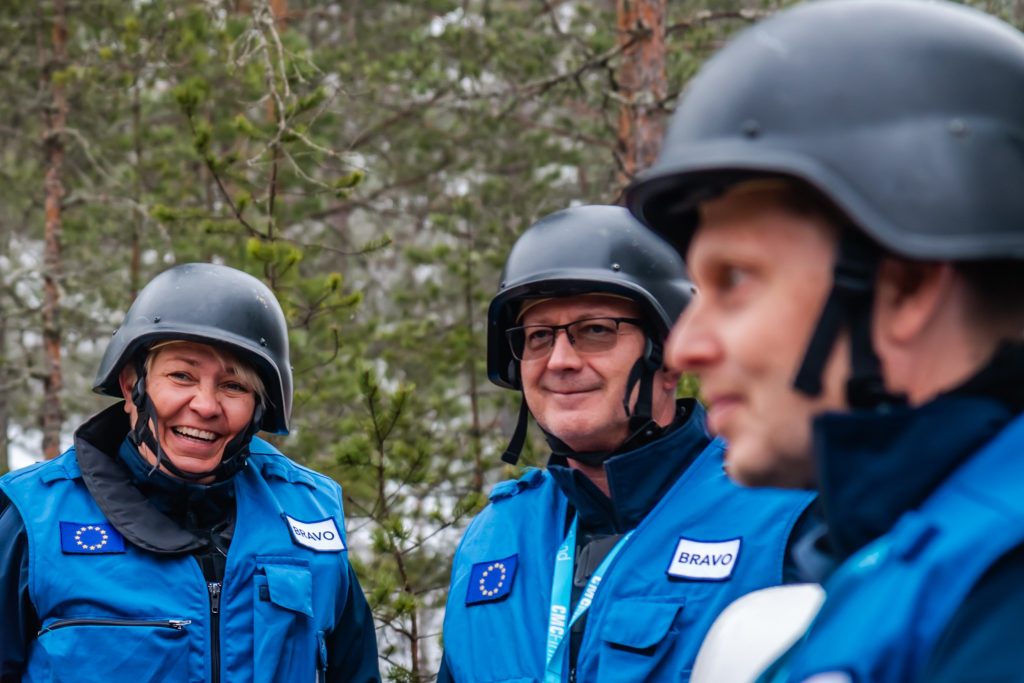 Kolme henkilöä pukeutuneena kurssivarustukseen kypärät päässä