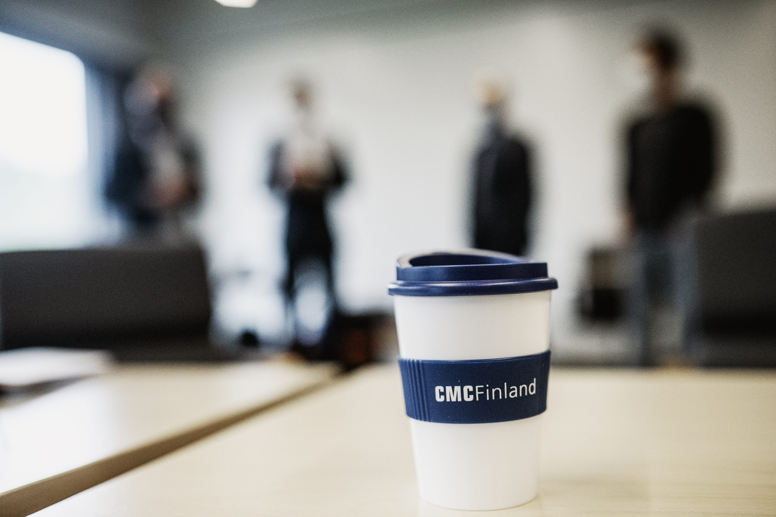 Etualalla CMC-muki, opiskelijoita taustalla